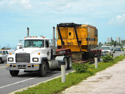 Export Logistics & Shipping, Inc. transports American 999C crawler crane car body by flat rack from San Juan to Cartagena along highway